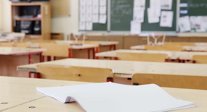 Elementary school desk with open notebook on it.