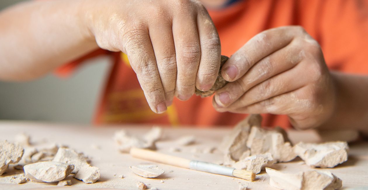 Kid playing with educational archaeology toy